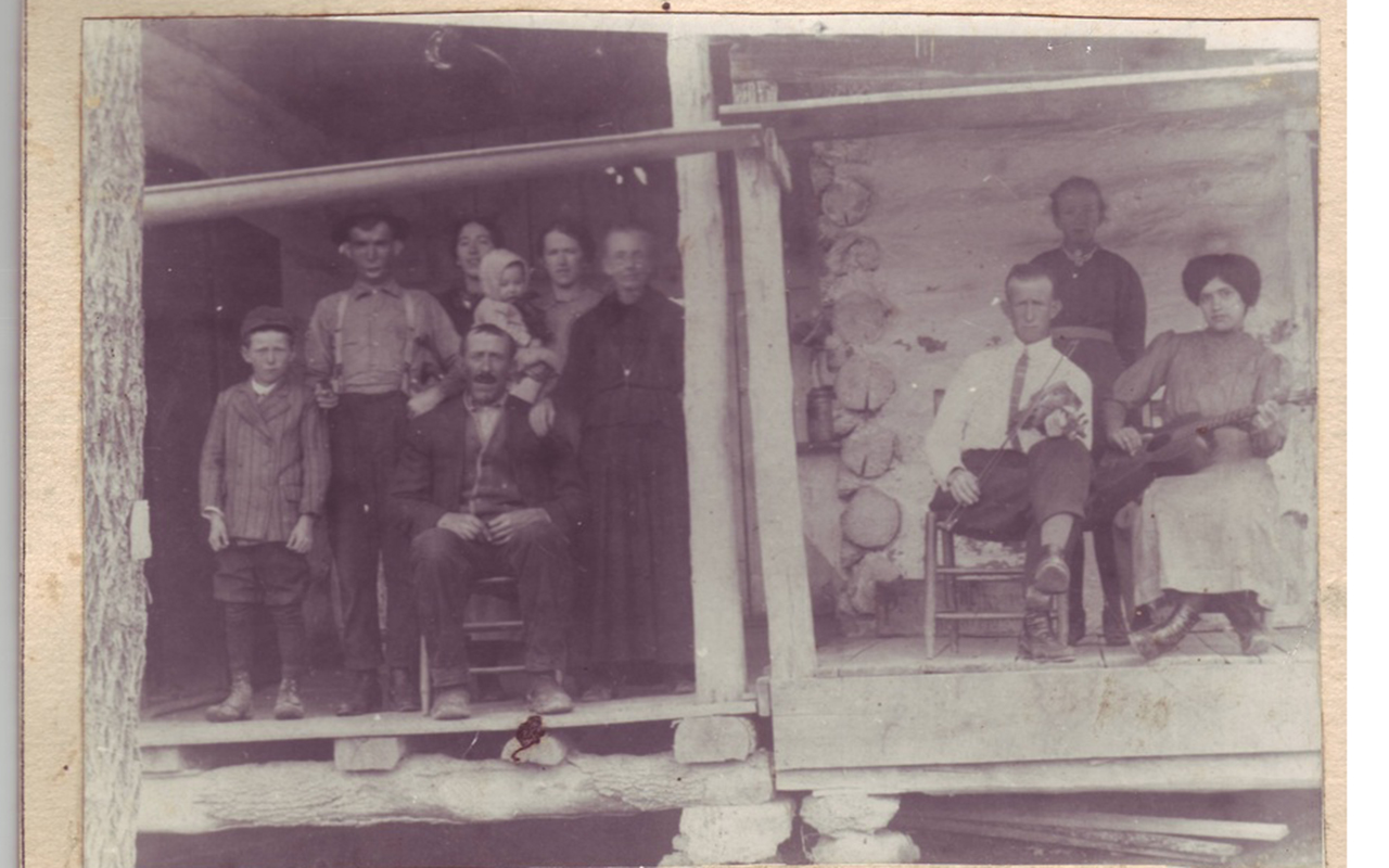 Frank Vess Portell family. The woman with the guitar is Nellie Hopkins Portell. She is wearing button shoes and has the Gibson Girl hairstyle. The man with the fiddle is Francis "Brazz" Politte. His descendants are known as the Brazz Polittes.